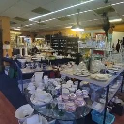 Uitgestalde serviesgoed, glazen en huishoudartikelen in de kringloopwinkel