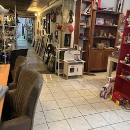 Winkelvloer van kringloopwinkel met diverse artikelen, stellingen, speelgoed en huishoudspullen