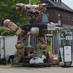Groot bronskleurig sculptuurwerk van twee figuren met een machinepistool, buiten opgesteld