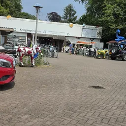Winkelgevel van Kringloop Enschede aan de Emmastraat met parkeerplaats en voetgangersgebied