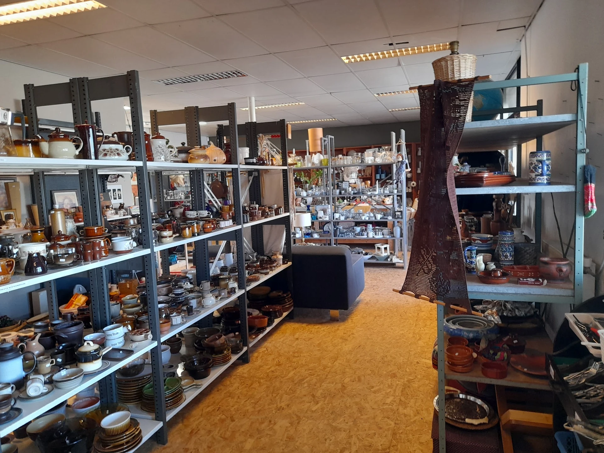 Winkelvloer met stellingen vol antiek, decoratieve spullen en serviesgoed
