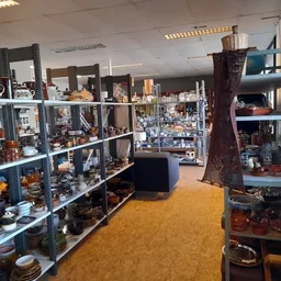 Winkelvloer met stellingen vol antiek, decoratieve spullen en serviesgoed