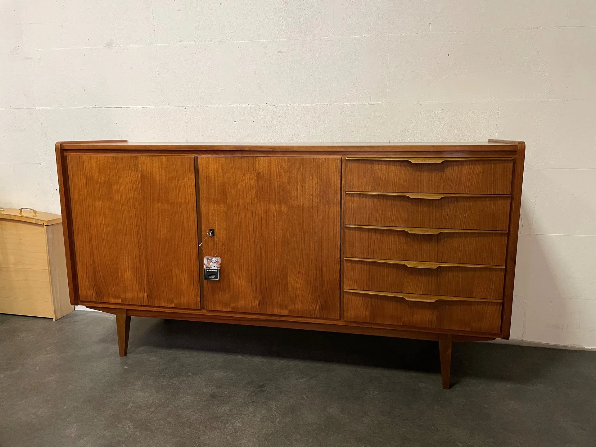 Houten vintage dressoir met kasten en lades in noten- of teakhoutkleur op spijlenpoten