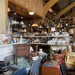Winkelvloer van kringloopwinkel vol met huishoudspullen, meubels, lampen en decoratieartikelen