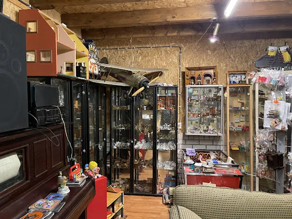 Interieur van kringloopwinkel met vitrines, verzamelstukken, oude televisies en diverse tweedehands spullen