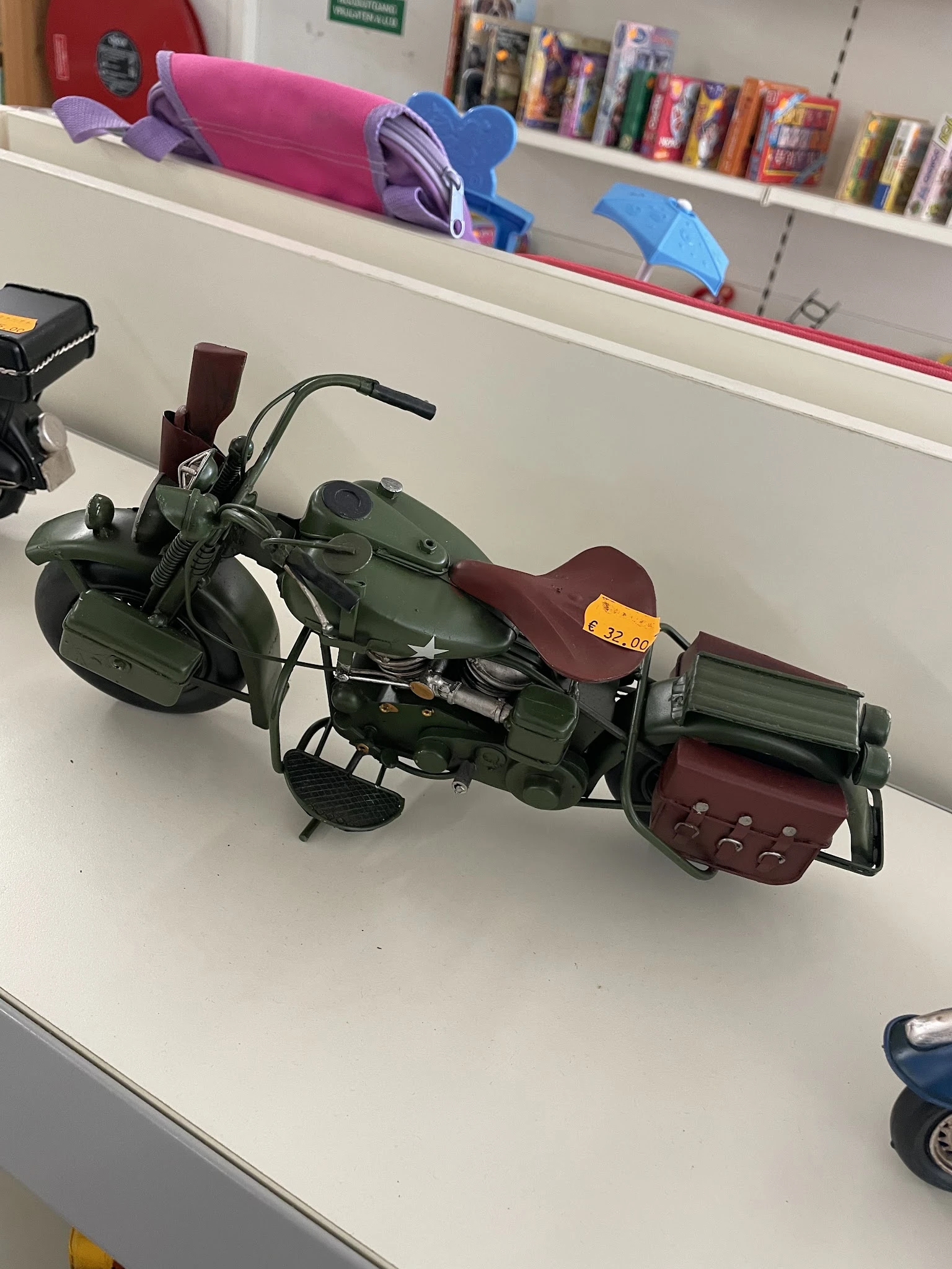 Speelgoedmotorfiets met zijspannen in groen en bordeauxrood, op een witte tafel