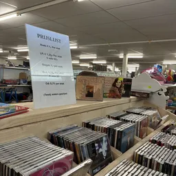 Uitgestalde cd's en dvd's in rekken met prijslijst boven de display