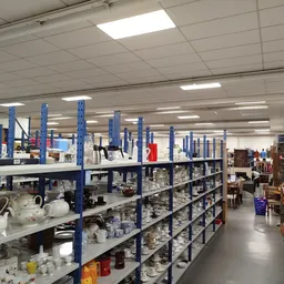 Winkelinterieur met blauwe stellingen vol huishoudartikelen en serviesgoed