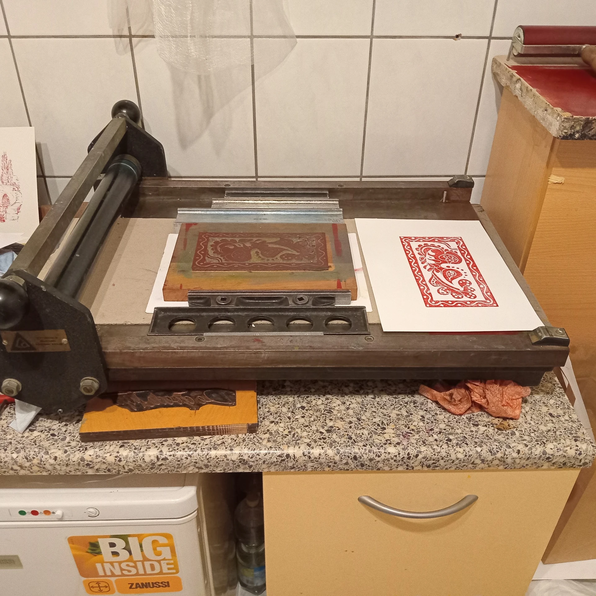 Vintage drukpers met decoratieve houten blokken en afdrukken op een werkbank