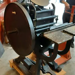 Tweedehands industriële drukpers of walsmachine met oranje frame en zwarte rollen