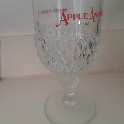 Kristallen wijnglas met rood Apple-logo aan de bovenkant
