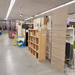 Winkelinterieur met houten stellingen, uitgestalde spullen en diverse merchandise langs de wanden