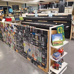 Winkelinterieur met een grote toonbank versierd met stickers, CDs en ander tweedehandsaanbod op planken