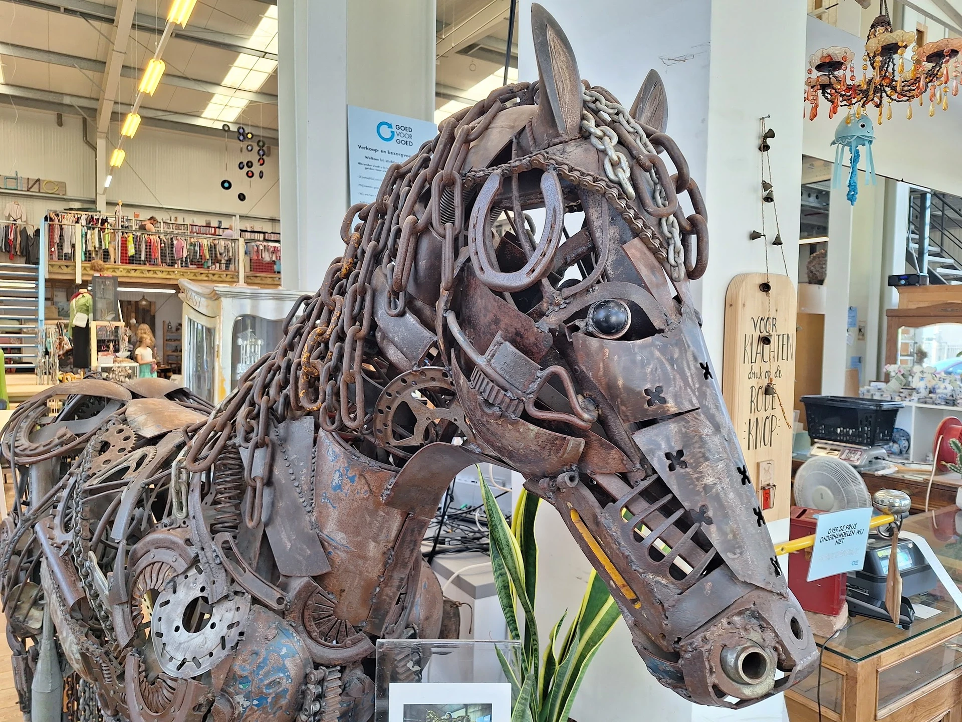 Decoratief paardenbeeld gemaakt van metaaldelen en onderdelen, tentoongesteld in een kringloopwinkel