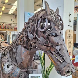Decoratief paardenbeeld gemaakt van metaaldelen en onderdelen, tentoongesteld in een kringloopwinkel
