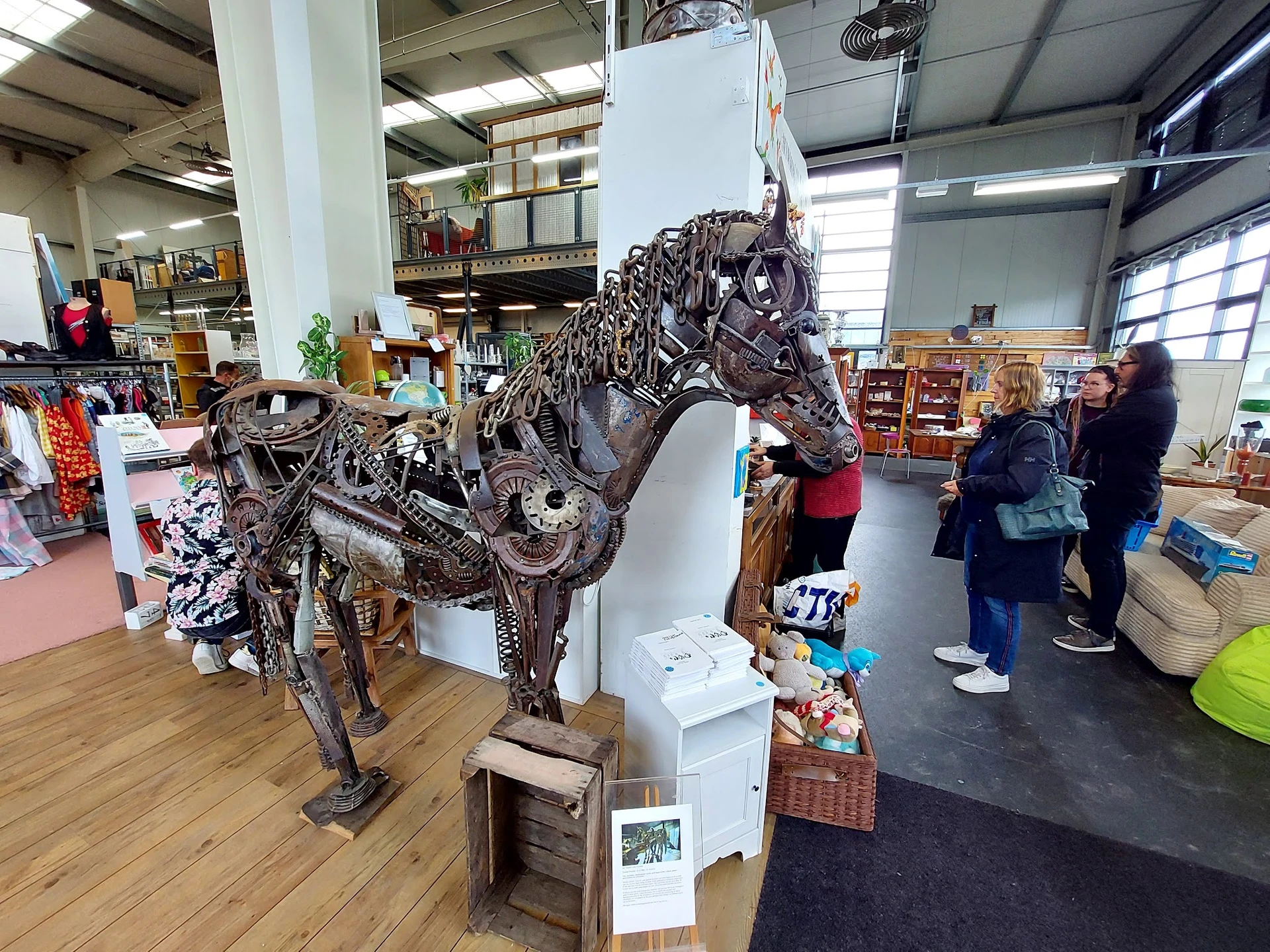 Groot decoratief paardenbeeld van metaal, tentoongesteld in een kringloopwinkel