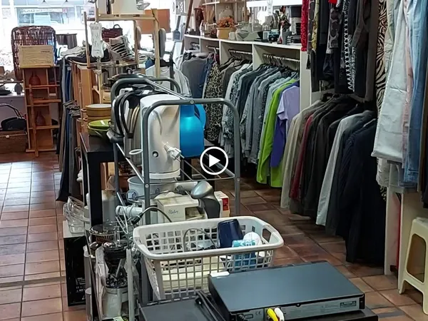 Winkelvloer met kledingrekken, stellingen en diverse tweedehands artikelen in kringloopwinkel