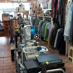Winkelvloer met kledingrekken, stellingen en diverse tweedehands artikelen in kringloopwinkel