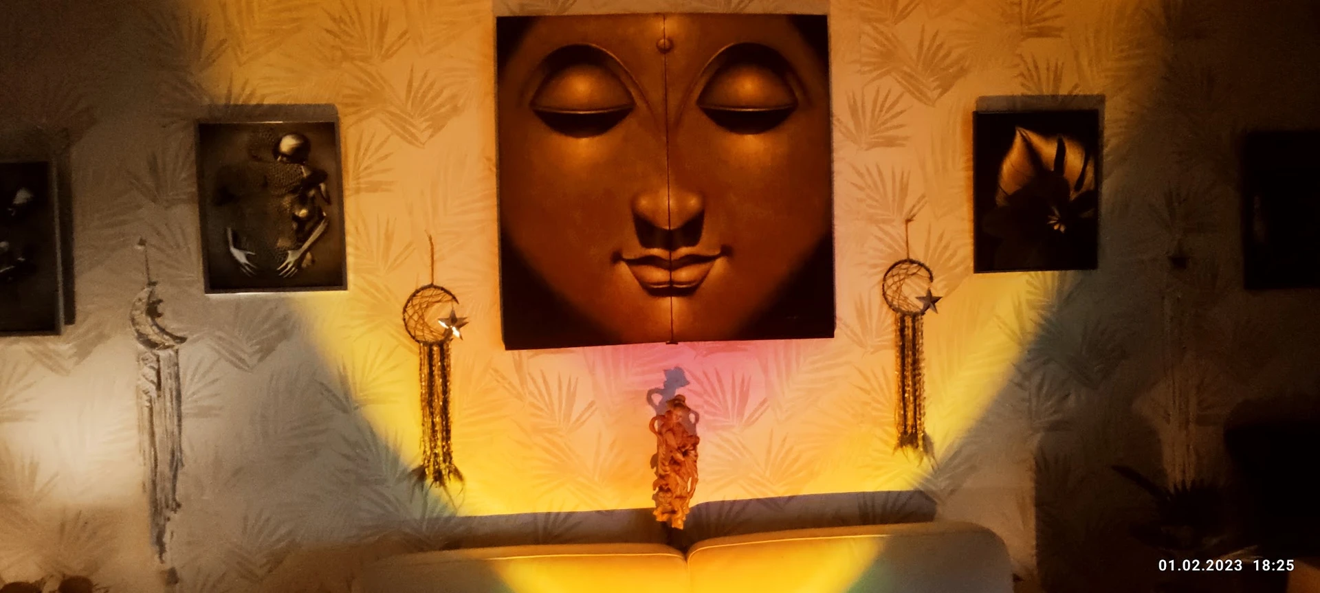 Winkelinterieur met groot bronzen gezichtsbeeld aan de muur, gele wandverlichting en decoratieve droomvangers