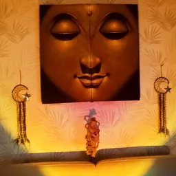 Winkelinterieur met groot bronzen gezichtsbeeld aan de muur, gele wandverlichting en decoratieve droomvangers