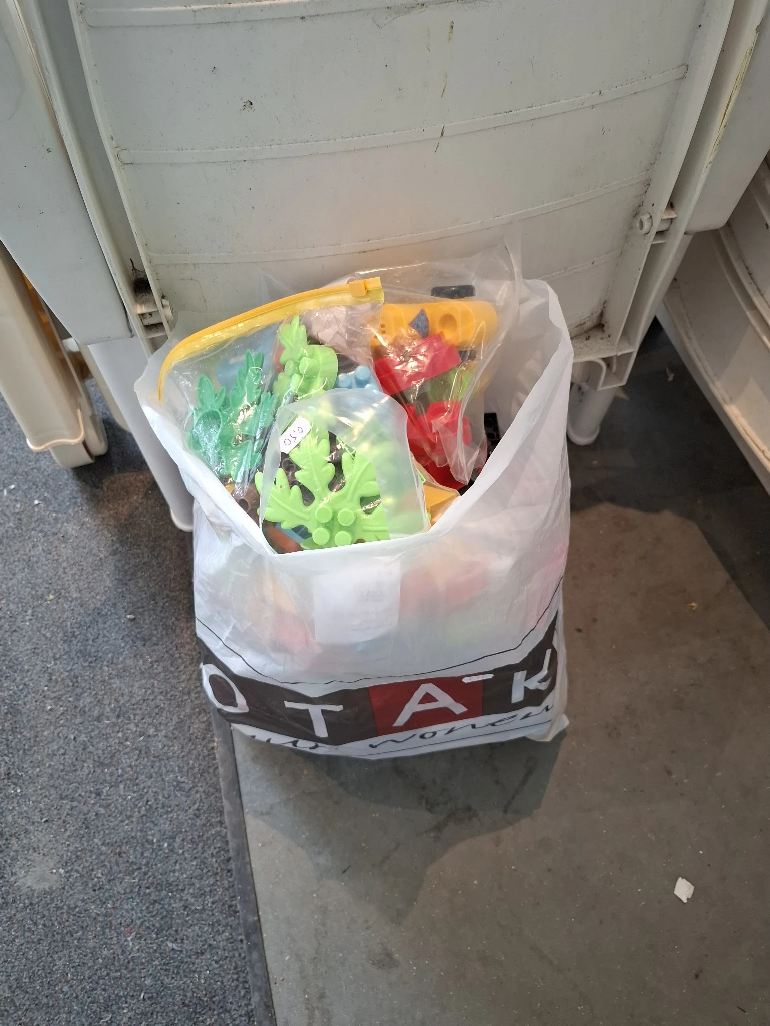 Plastic tas met groenten waaronder paprika's, sla en ander fruit en groente