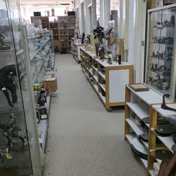 Winkelinterieur met houten schappen en witte werkbladen langs beide zijden van het gangpad
