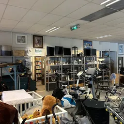 Overzicht van kringloopwinkel met boekenkasten, speelgoed, fietsen en diverse tweedehands artikelen