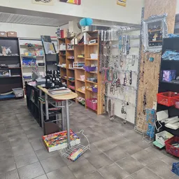 Winkelvloer van kringloopwinkel met stellingen, rekken en kasten vol spullen; diverse artikelen uitgestald op verschillende n
