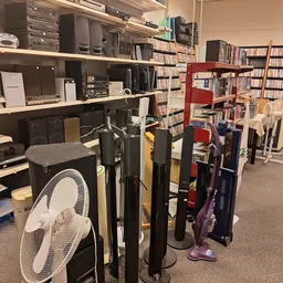 Winkelinterieur met dvd-verzameling, elektronica en diverse huishoudelijke artikelen op planken en stellingen