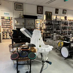 Winkelvloer met muziekinstrumenten: keyboards, drums, piano en verschillende instrumenten in kringloopwinkel