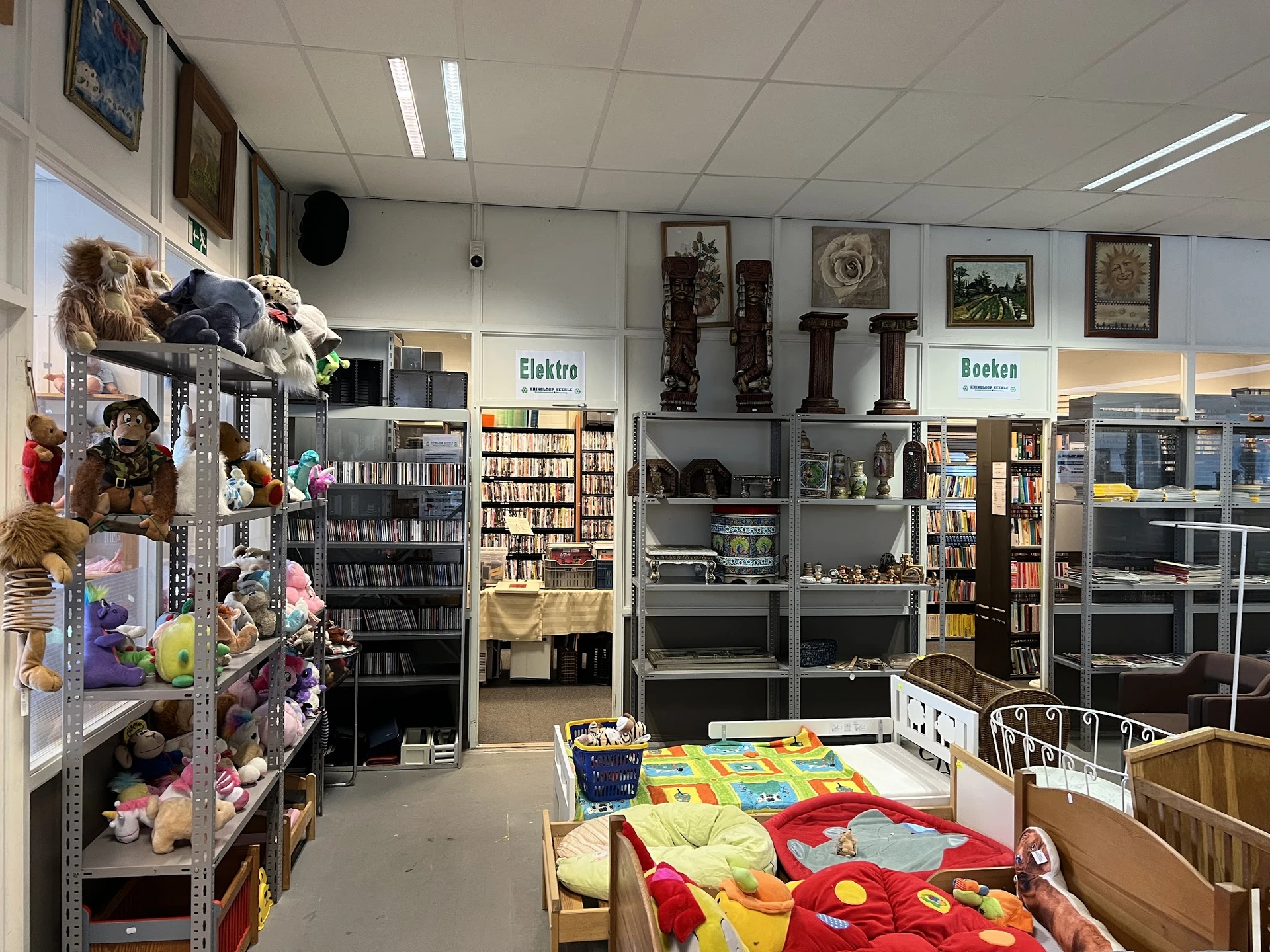 Winkelvloer van kringloopwinkel met speelgoed, boeken, huishoudartikelen en verschillende afdelingen