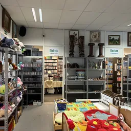 Winkelvloer van kringloopwinkel met speelgoed, boeken, huishoudartikelen en verschillende afdelingen