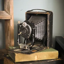 Vintage vouwcamera met bellows in open staat, zwart met metalen details, in bruin koffertje