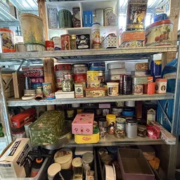 Stellingen vol vintage blikken, dozen en decoratieve items in verschillende kleuren en stijlen