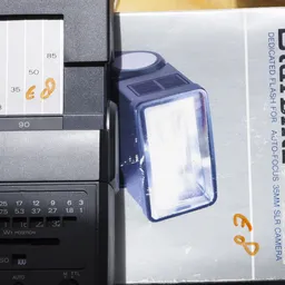 Blauwe led-cameralamp in verpakking met maat- en gewichtsaanduidingen op achtergrond