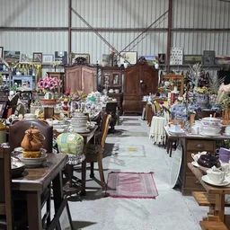 Overzicht van kringloopwinkel met meubels, servies, decoratie en diverse tweedehands spullen uitgestald