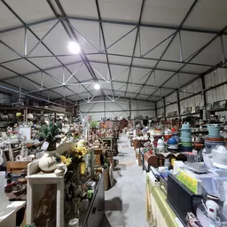 Ruim magazijn met stellingen vol servies, vazen, lampen en huishoudelijke spullen