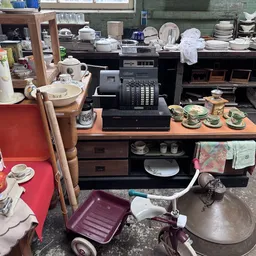 Verzameling huishoudelijke artikelen en serviesgoed uitgestald in een kringloopwinkel