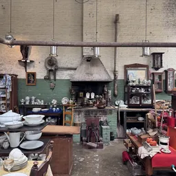 Vintage keukeninterieur met oude fornuis, servies, meubels en huishoudspullen uit vroeger tijden