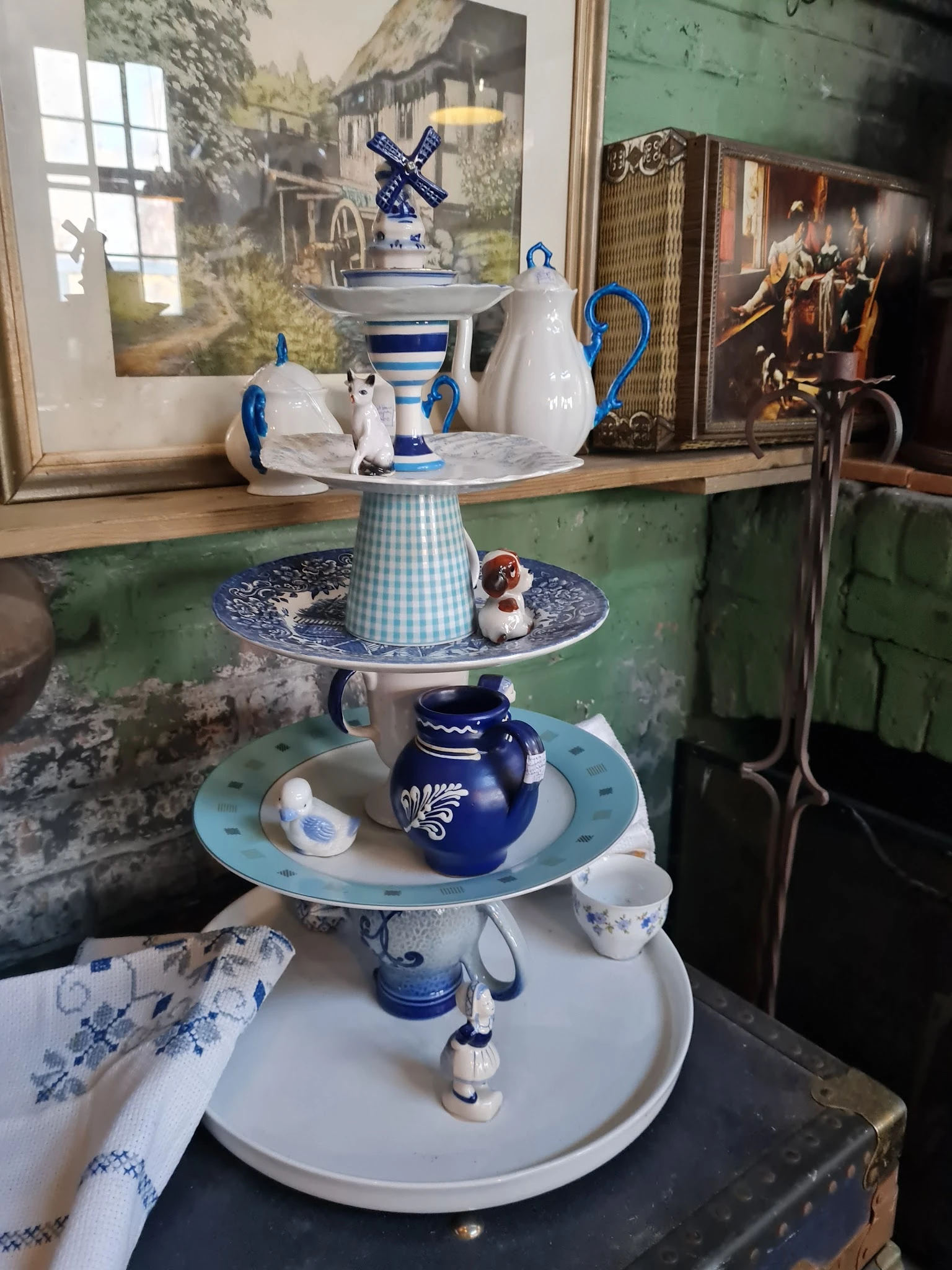 Decoratief serviesgoed gestapeld op een blauw-wit serveerstandaard met onderzetters