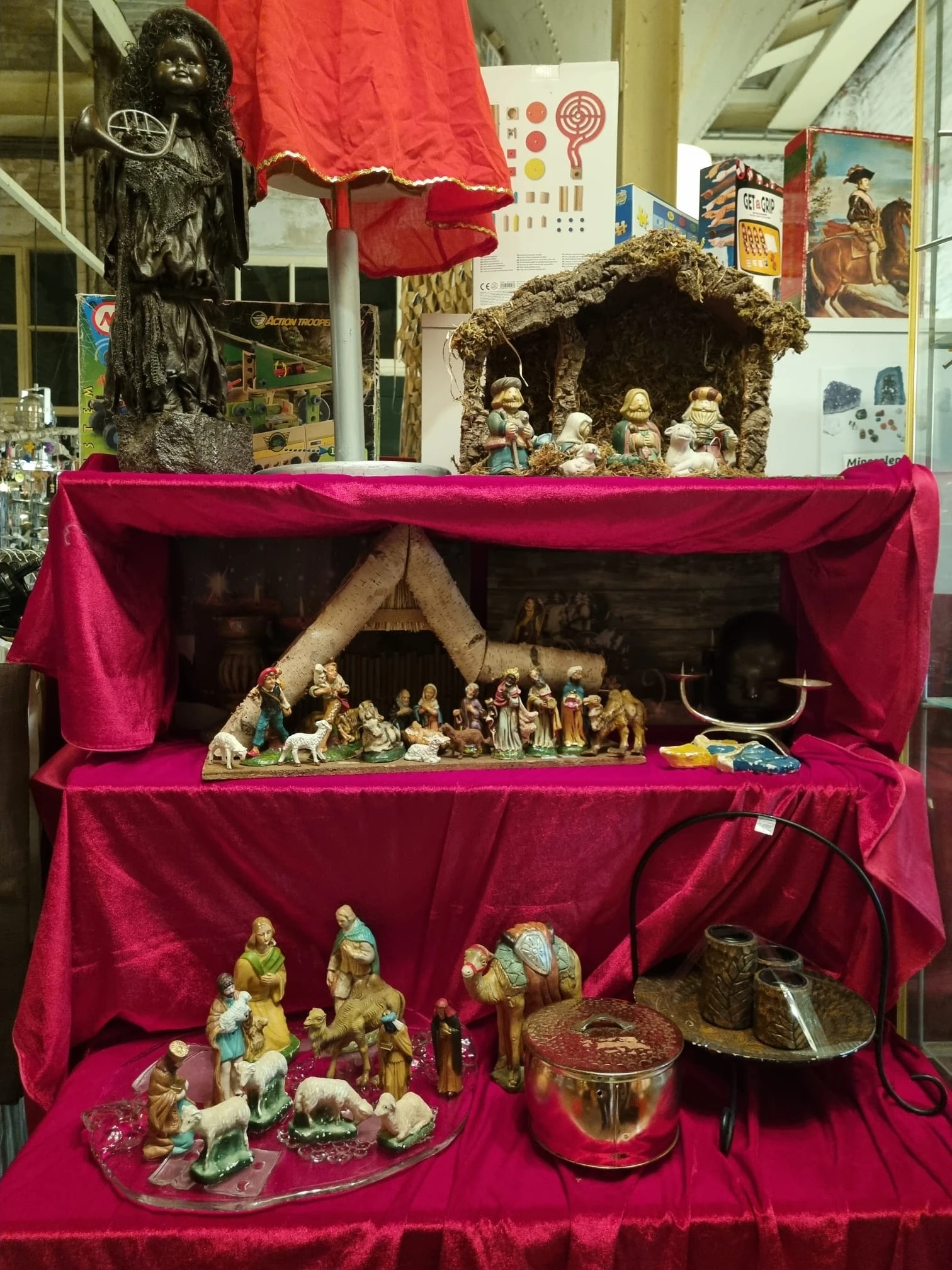 Religieuze beeldjes en kerststallen in roze fluwelen vitrinekast