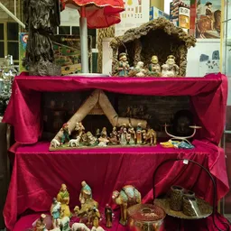 Religieuze beeldjes en kerststallen in roze fluwelen vitrinekast