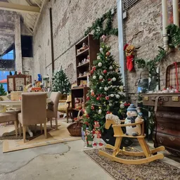 Interieur van kringloopwinkel met kerstdecoratie, meubilair en vintage spullen uitgestald