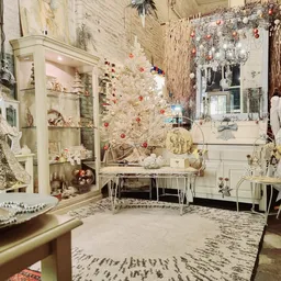 Kerstdecoratie en winkelinrichting met witte kast, kerstboom, sieraden en kledingrek in de kringloopwinkel