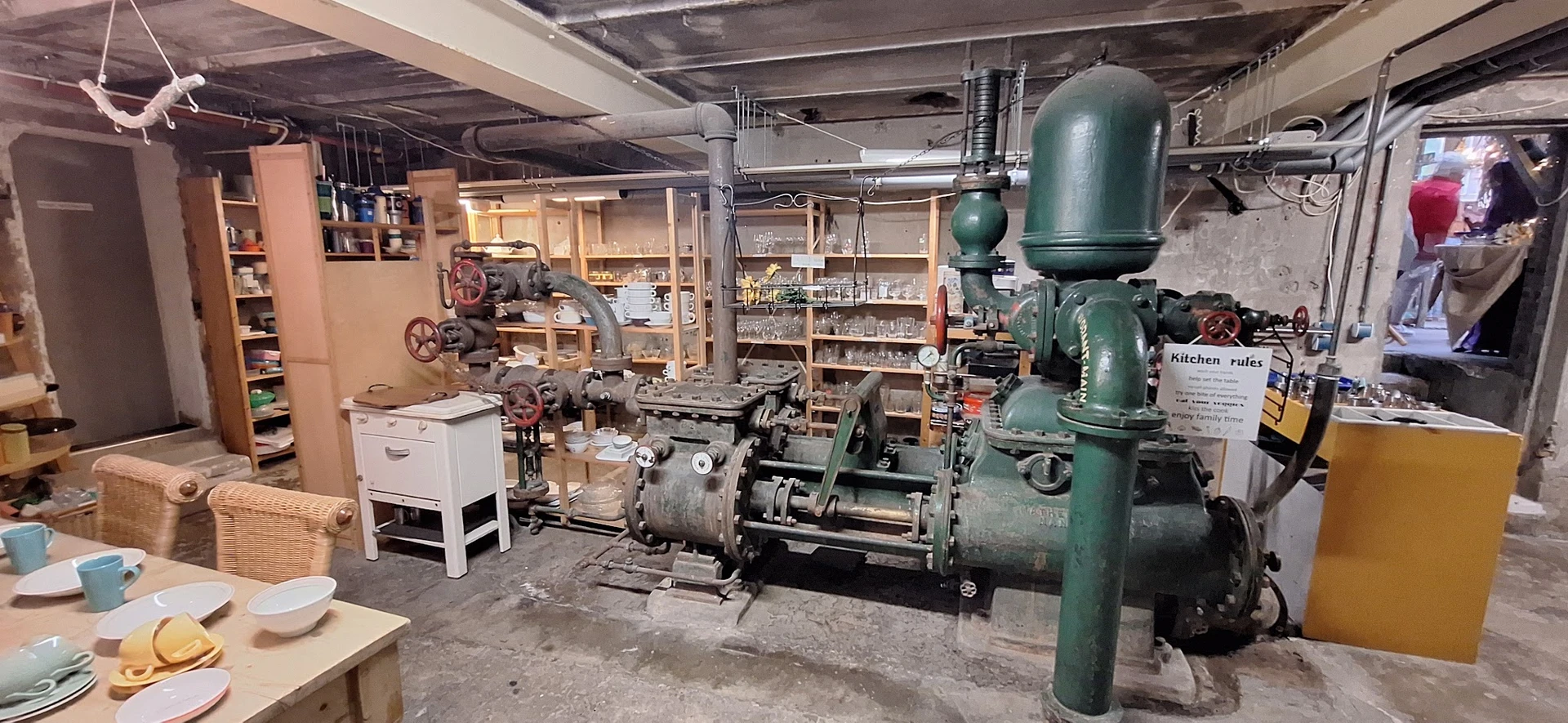 Werkplaats met oude groene industriële machines en stellingen vol met voorwerpen