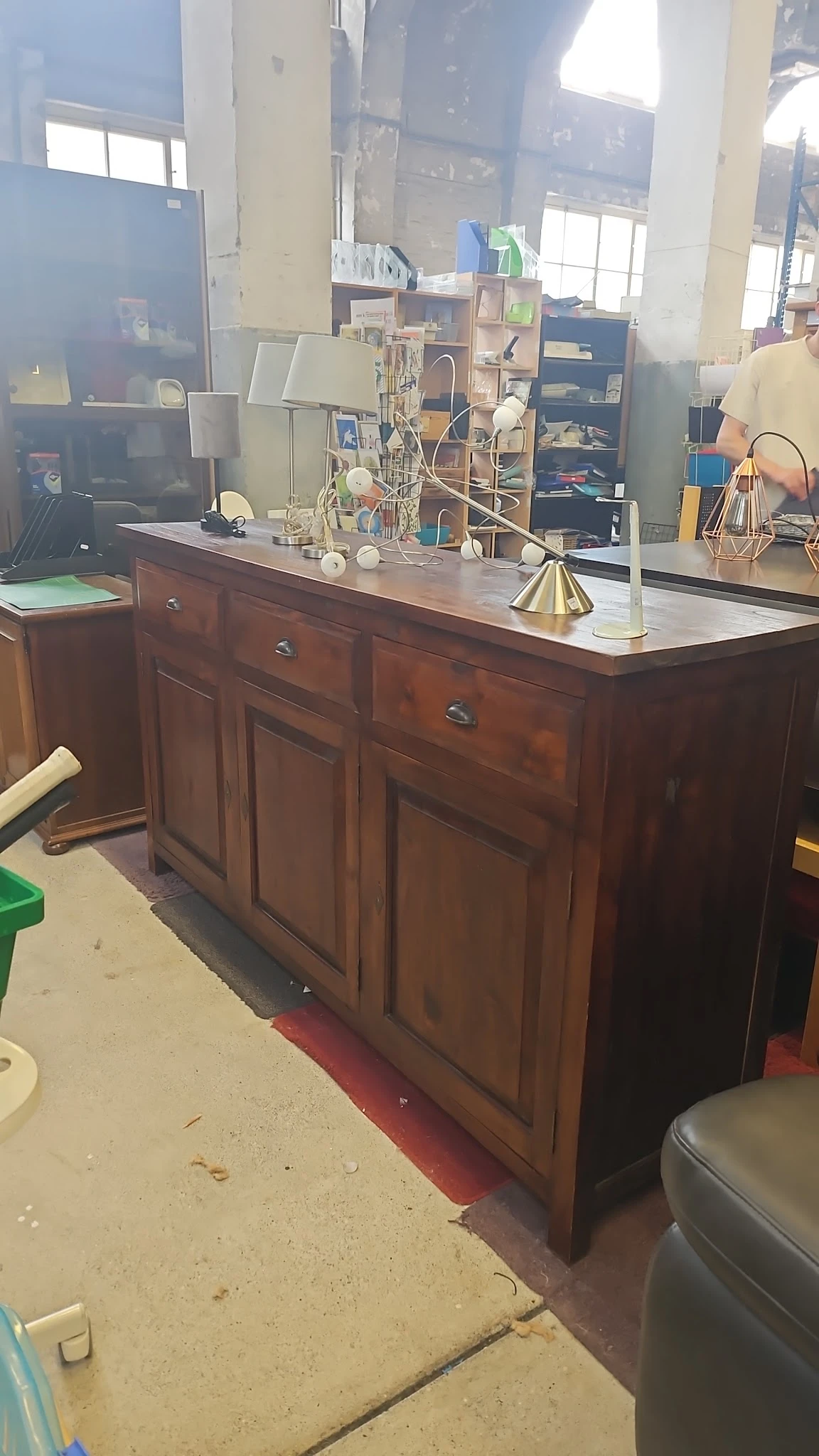 Houten bureau met witte blad en messing bureaulamp, gevuld met decoratieve items