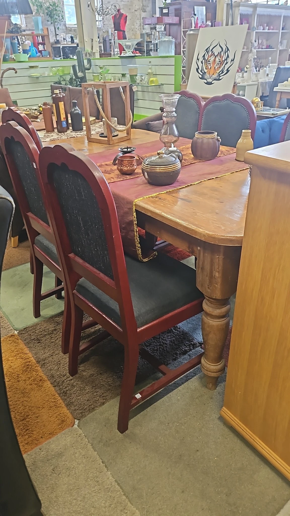 Houten eettafel met rood geschilderde stoelen met zwarte zitting