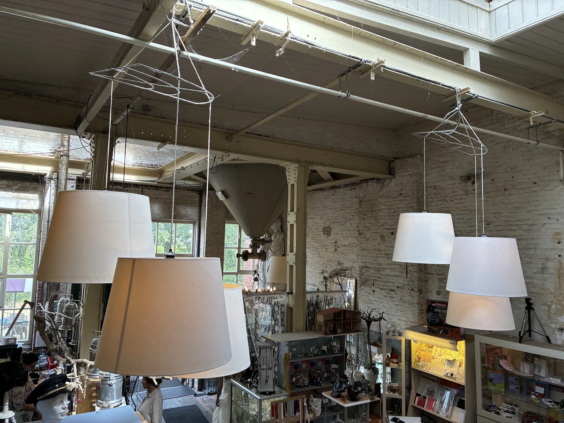 Hanglampen met witte kappen in verschillende formaten, uitgestald in de kringloopwinkel