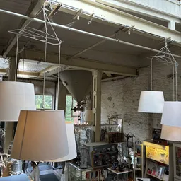 Hanglampen met witte kappen in verschillende formaten, uitgestald in de kringloopwinkel