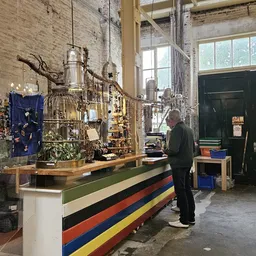 Winkelvloer met houten toonbank, kunstvoorwerpen en installaties, bezoeker in het interieur